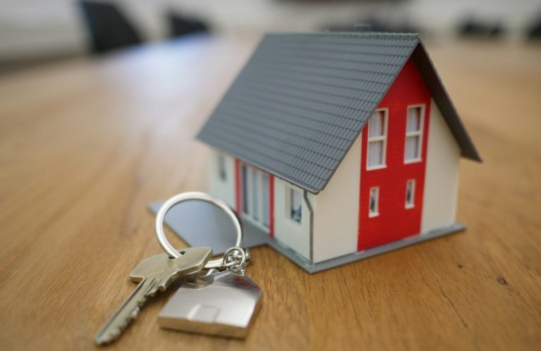 Modellhaus mit Hausschlüssel als Symbol für privaten Versicherungsschutz
